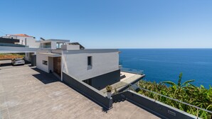 Ein modernes Wohngebäude mit Dachterrasse und Blick auf das Meer.