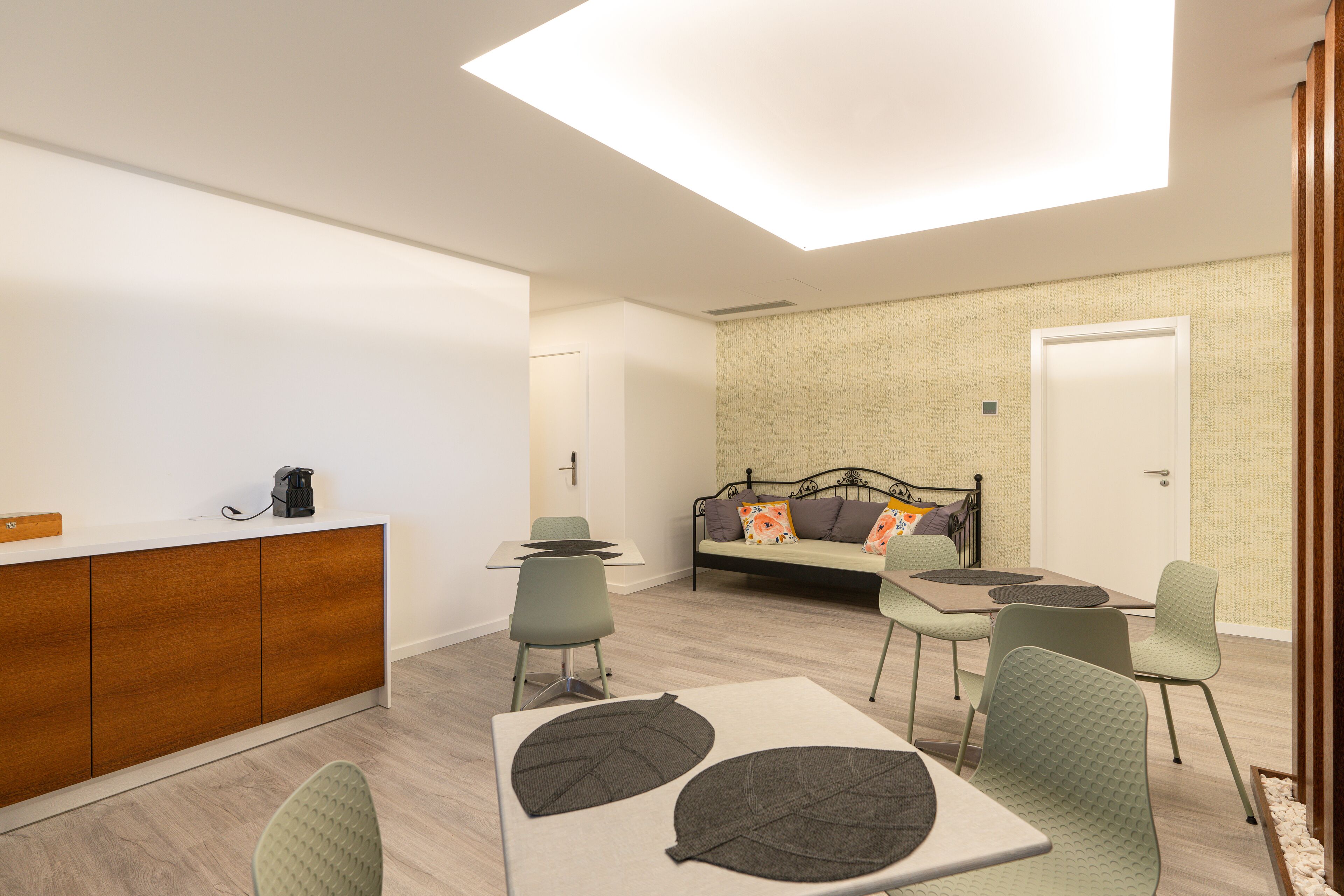 Una habitación moderna y bien iluminada con comedor, sofá y cama.