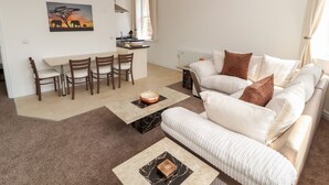 A modern living room with a sofa, coffee table, and dining area.