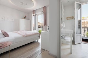 Un dormitorio con cama, mesita de noche, armario y baño con lavabo y ducha.