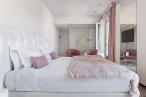 A modern bedroom with a large bed, a glass door leading to a bathroom, and a view of a cityscape. - Eurostars Florence Boutique (Florence)