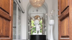 A foyer with a black circular base, a white statue, and a white vase with flowers. - Eurostars Florence Boutique (Florence)
