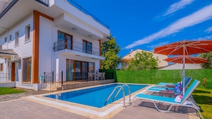 A modern two-story house with a swimming pool, outdoor seating, and a well-maintained garden. - Myra Villa 1 (Fethiye)