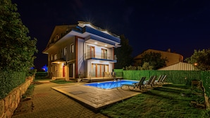 A two-story house with a swimming pool, outdoor seating, and a well-maintained garden. - Myra Villa 1 (Fethiye)