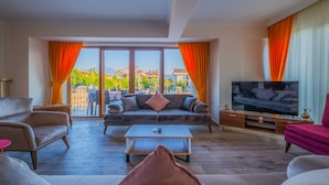 A spacious living room with a sofa, armchairs, a coffee table, and a TV. - Myra Villa 1 (Fethiye)