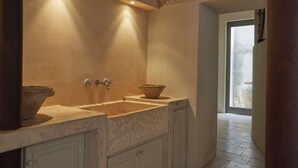 Une salle de bain dotée d’un double lavabo, d’un grand miroir et d’une fenêtre laissant entrer la lumière naturelle.