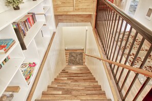 Staircase with a reading nook featuring shelves with books and magazines.
