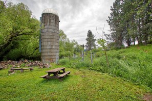 Experience the serene tranquility of a rustic countryside setting, surrounded by lush greenery and a historic silo.
