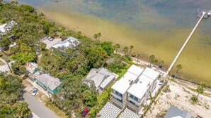 An aerial view of a coastal area with buildings, a pier, and a clear view of the water. - Stunning River Views - Historic 3br Walk Dntn (Melbourne)