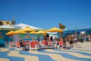 A beachside area with outdoor seating and umbrellas.