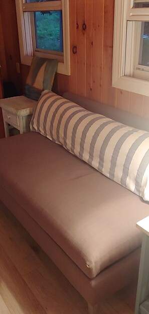 Relax in a cozy room with a comfortable bed, small dining table, and a window offering a view of the outdoors.