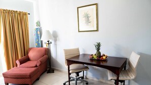 A room with a dining table, two chairs, a red armchair, a lamp, and a framed picture on the wall. - The Paradise Inn (Philipsburg)