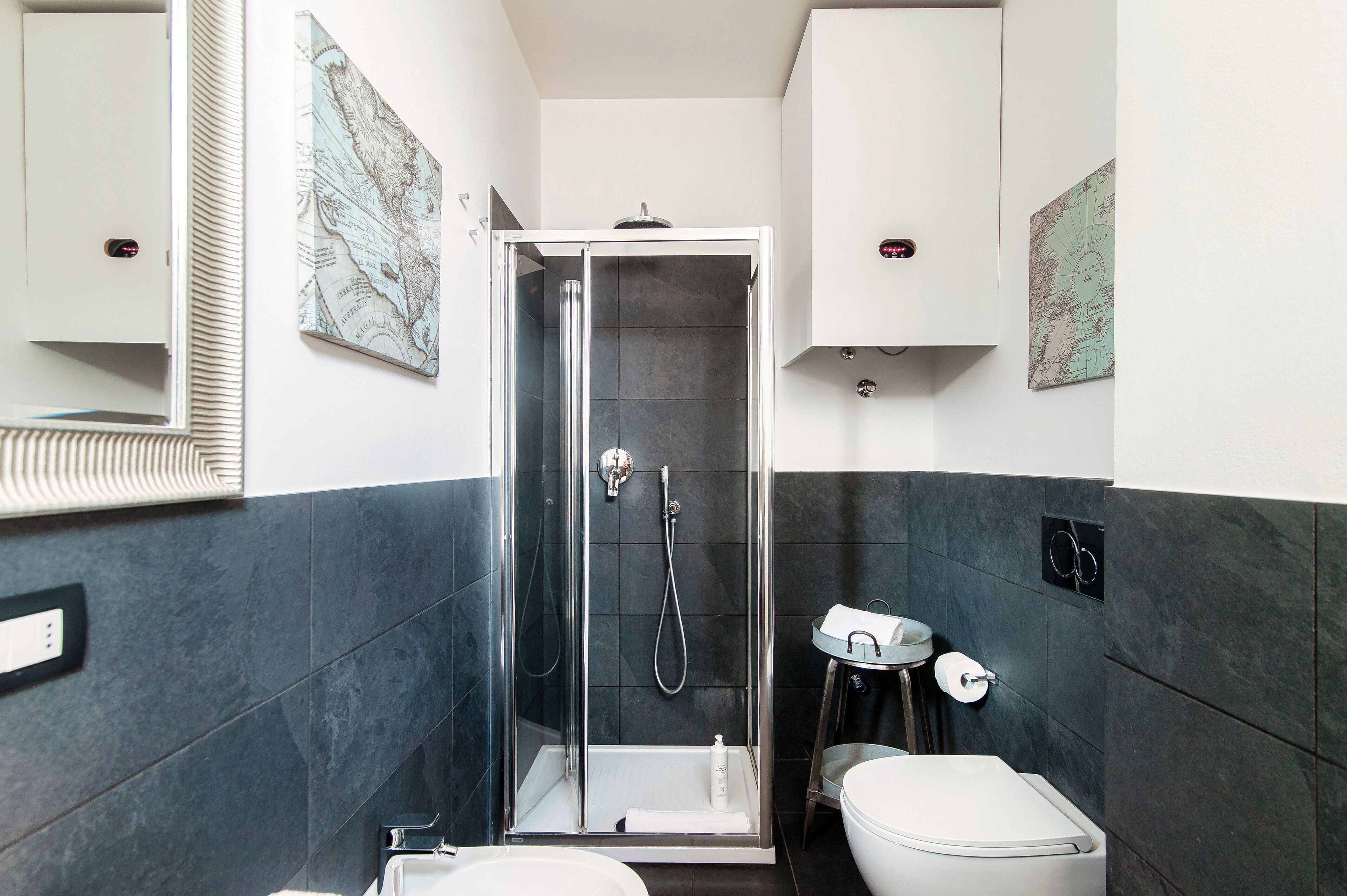A modern bathroom with a glass-enclosed shower, a white toilet, and a small sink.