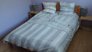 A bedroom with a bed, two nightstands, a wall-mounted picture, and a wooden floor. - Gîte Pour 8-10 Personnes Avec vue Imprenable ! (Gérardmer)