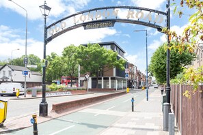 Un panneau de signalisation indiquant « ZONE COMMERCIALE DE LONDON ROAD », avec une piste cyclable, un arrêt de bus et un passage piéton.