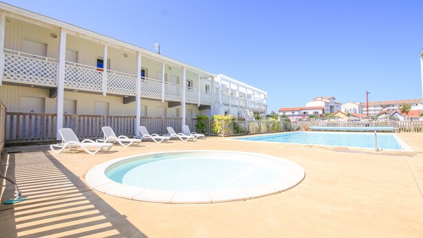 Un hôtel doté d’un espace piscine comprenant des chaises longues et une piscine.