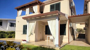 A two-story house with a covered patio, a swimming pool, and a well-maintained garden. - Casa Maria (Tanaunella)