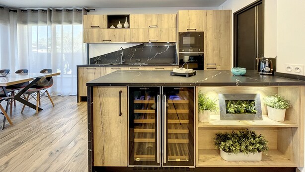 A modern kitchen with wooden cabinets, a black countertop, and built-in appliances. - Villas A du Golf Mougins (Mougins)