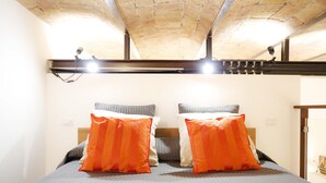 A room with a high ceiling, exposed brick, and a bed with two pillows. - Casa Opera lovely apartment in Rome (Roma)
