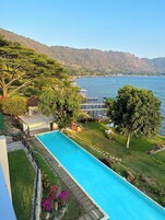 Piscina con vistas a un lago y montañas.
