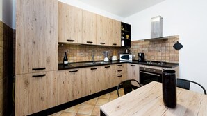 Een moderne keuken met houten kastjes, een zwart aanrecht en een fornuis.