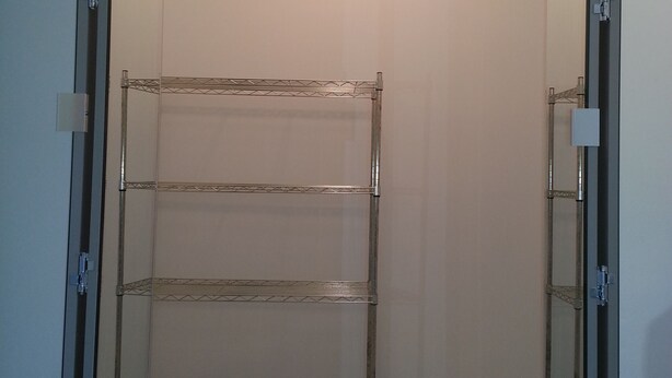 A walk-in closet with a metal shelving unit, a ceiling light, and a door with a handle. - Summer Rental - Great Location - West End Section of Long Branch - Walk to beach (Long Branch)