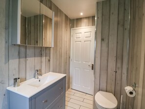 Un baño con lavamanos, espejo y retrete.
