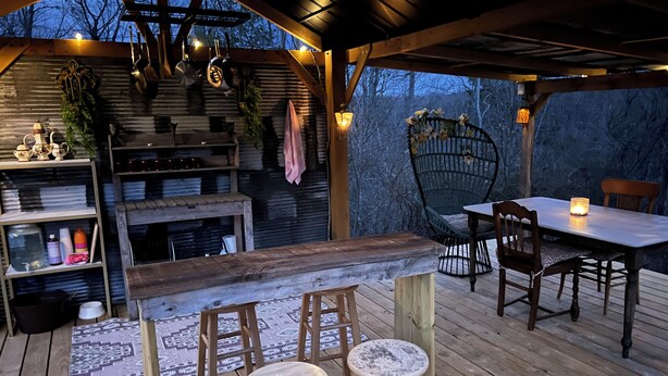 A wooden deck with a bar area, seating, and a grill.