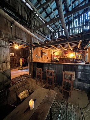Eine rustikale Bar mit Holzzimmermöbeln, einer Theke und einer Decke mit freiliegenden Balken.