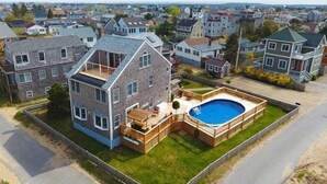 Une maison à deux étages avec une piscine, une terrasse et une cour clôturée.