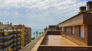 Une terrasse sur le toit offrant une vue sur la mer, entourée d’immeubles de grande hauteur.