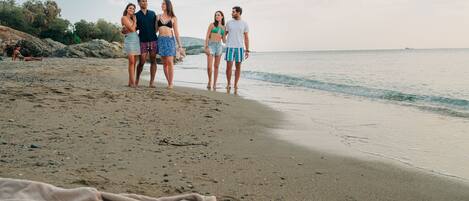 Una playa con gente caminando por la orilla.