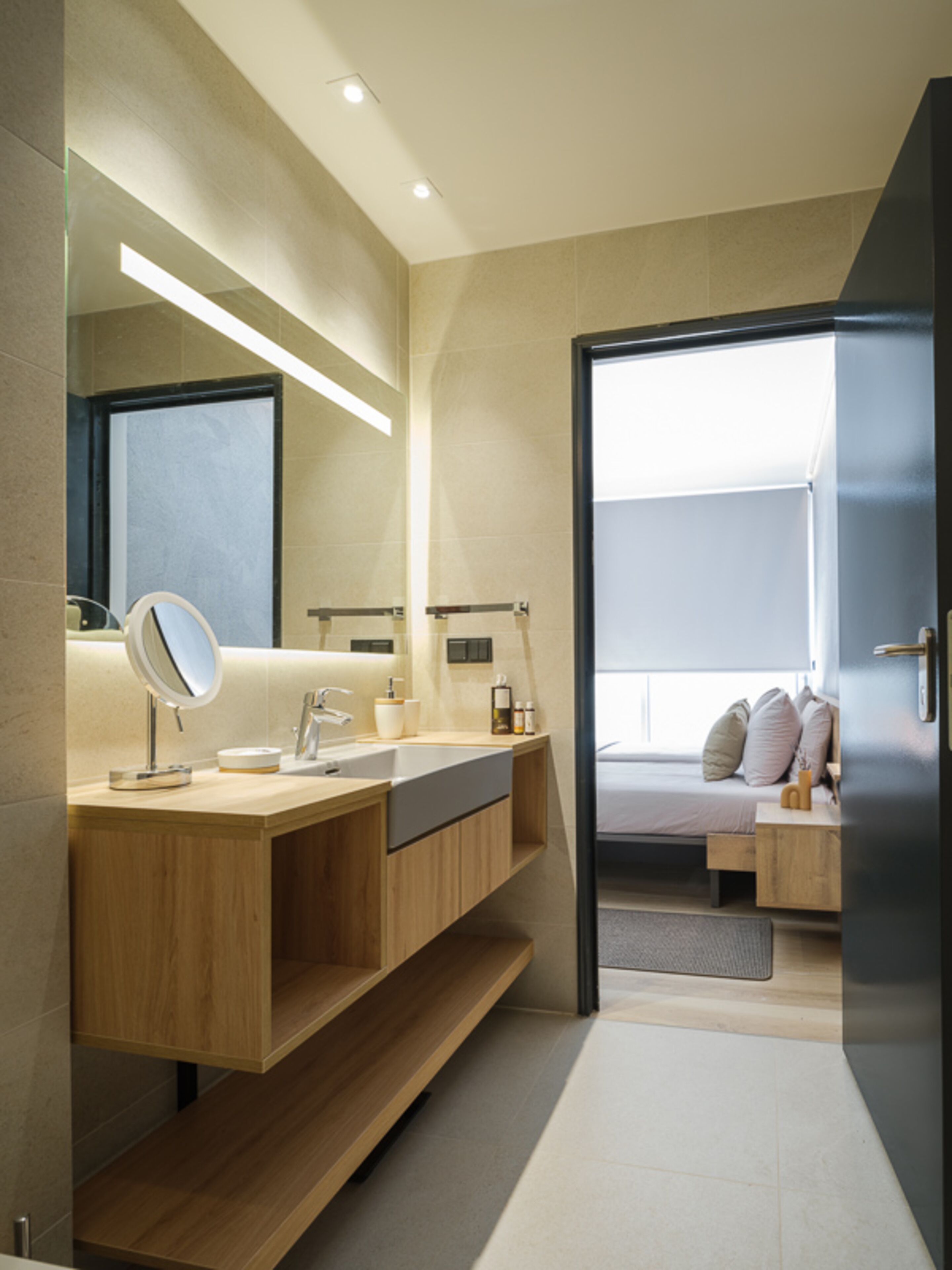 A modern bathroom with a wooden vanity, a large mirror, and a built-in shower.