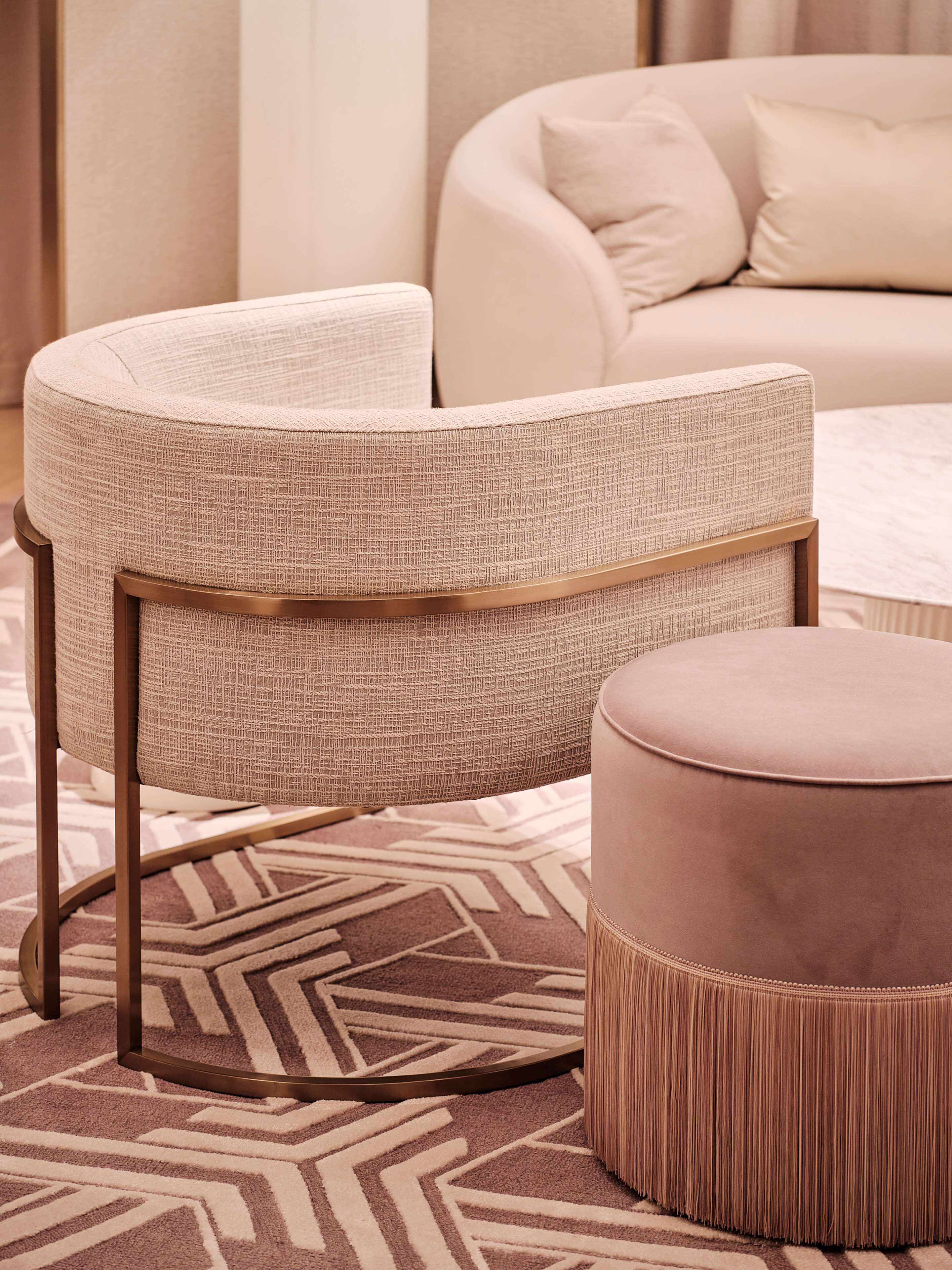 Un sillón moderno con tela texturizada y estructura de madera, sobre una alfombra estampada.