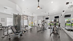Un gimnasio moderno con diverso equipo de ejercicio, ventanas amplias y un diseño limpio y espacioso.