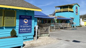 A blue building with a sign reading "Fishy Fishy Cafe" and contact information.