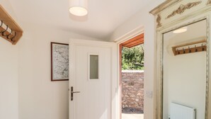 A white door with a small window, a radiator, and a wooden coat rack.