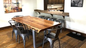 A dining area with a wooden table and metal chairs, a kitchen with dark wooden cabinets, and a framed picture on the wall. - Pet-friendly 5 bed/4 bath home, just minutes to Beaver Creek, Avon, and Vail (Avon)