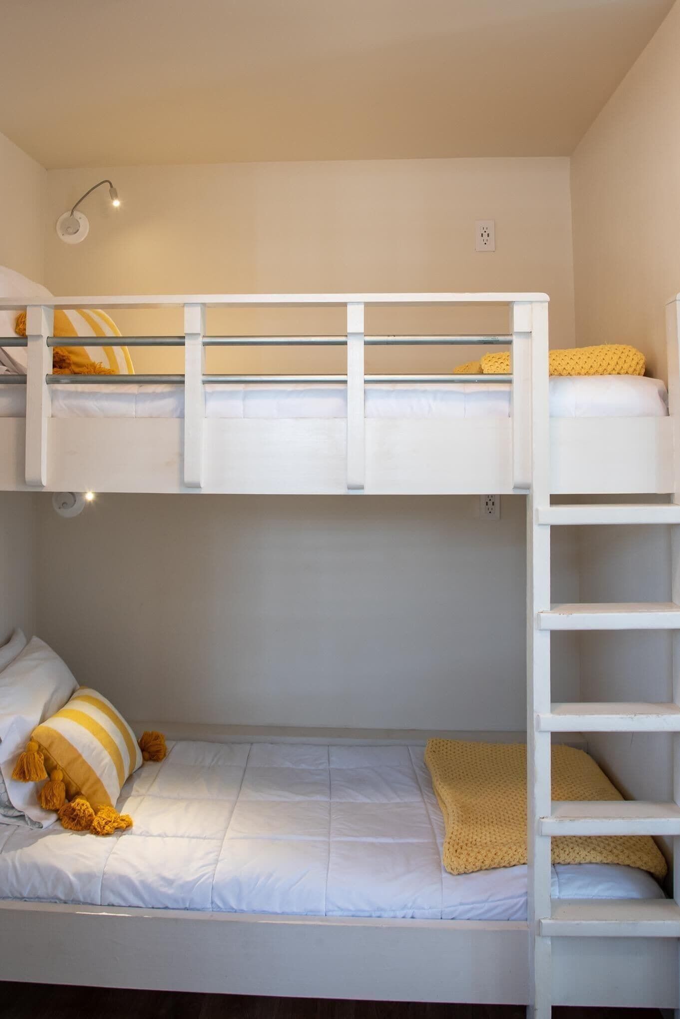 Habitación con literas, una mesita de noche y una lámpara.