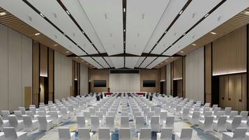 Ein großer Konferenzraum mit Reihen weißer Stühle und einer Bühne im vorderen Bereich.