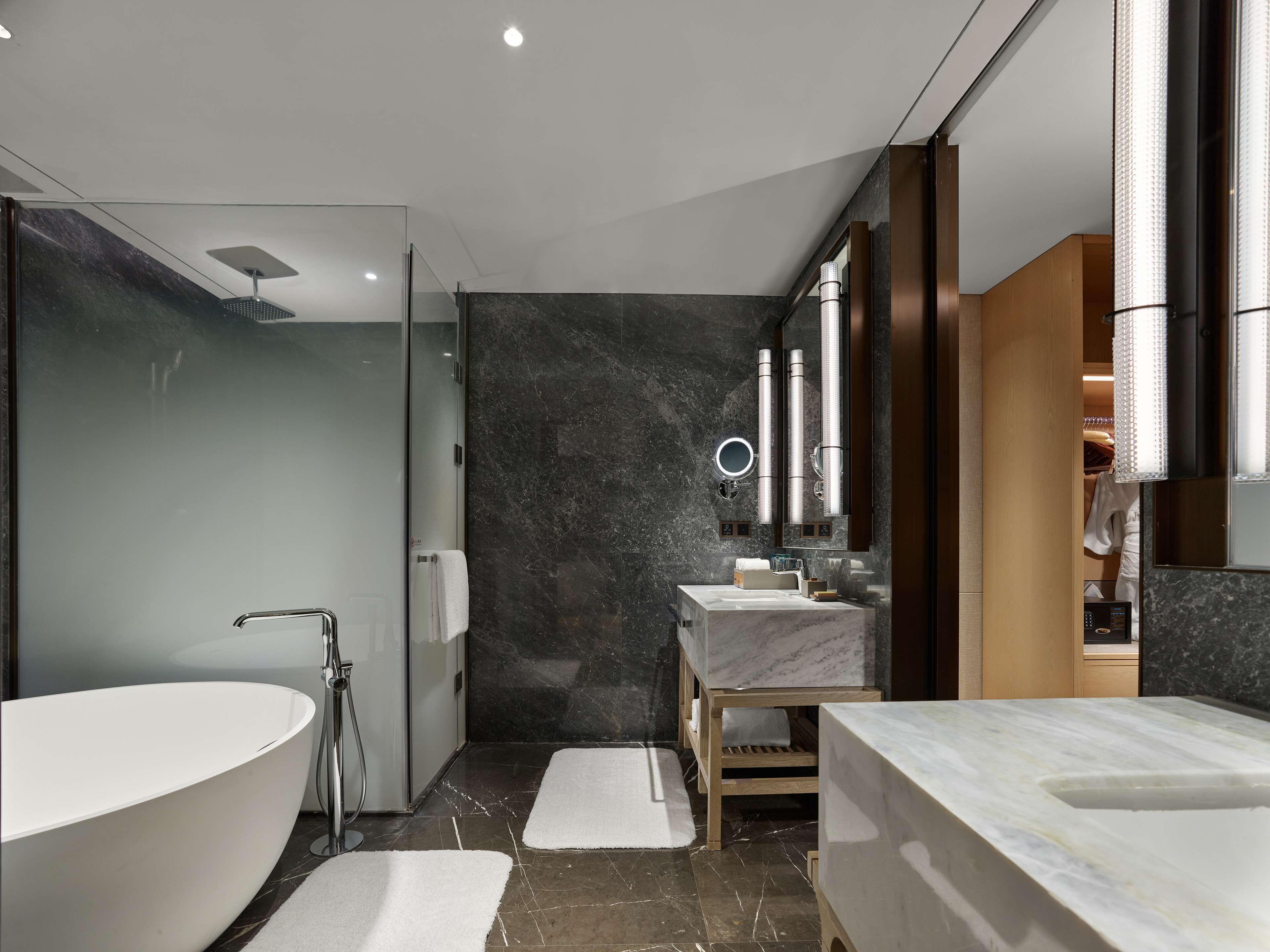 Un baño moderno con una bañera independiente, un tocador con espejo y una zona de ducha.