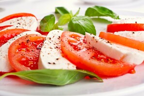 A plate of Caprese salad with tomatoes, mozzarella, and basil.