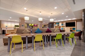 Relax in a comfortable lounge area with a sofa, long table, and flat-screen TV.