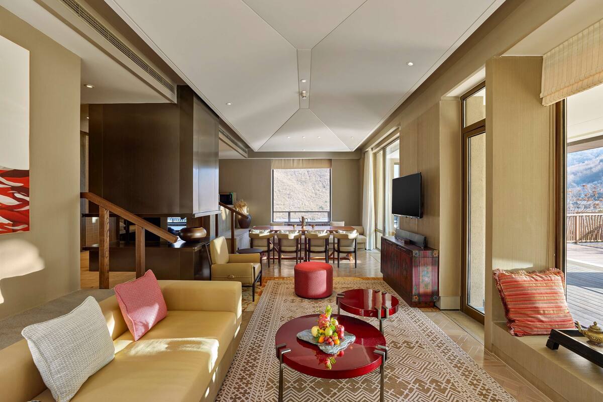A spacious living room with a sofa, coffee table, and a dining area with chairs.
