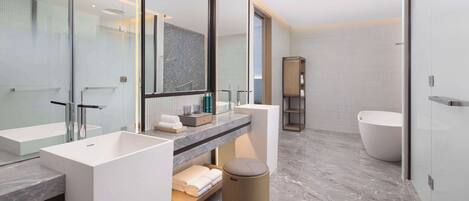Un baño moderno con dos lavamanos, un espejo grande, una bañera y un mueble de tocador con toallas.