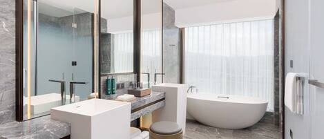 Un baño moderno con un espejo grande, una bañera y un lavamanos.