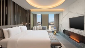 Ein modernes Hotelzimmer mit einem großen Bett, einem Fernseher und einem Kamin.