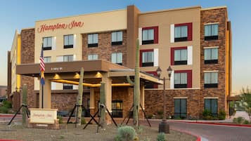 Experience the Hampton Inn's modern design, featuring a prominent entrance and beautifully landscaped surroundings.