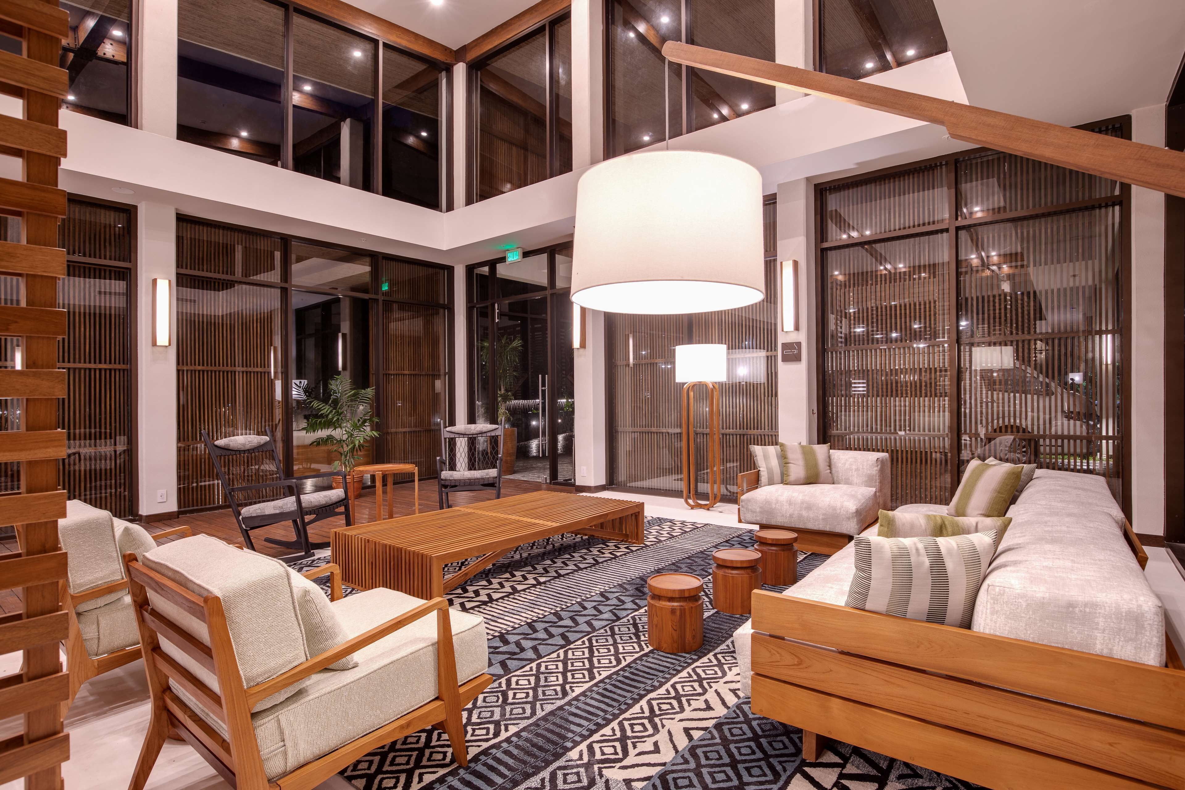 Eine großzügige Lobby mit hoher Decke, Holzmöbeln und großen Fenstern.