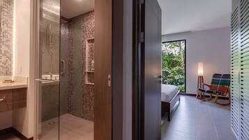 Een moderne badkamer met een douchecabine van glas, een houten wastafelmeubel en een betegelde douche.